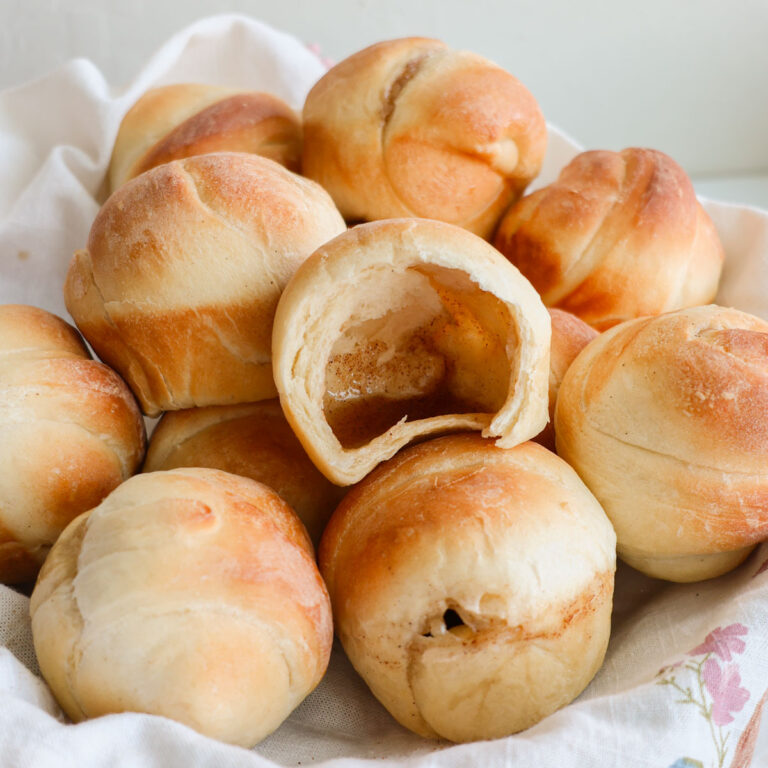 A basket full of Resurrection rolls with one open showing the hollow interior.